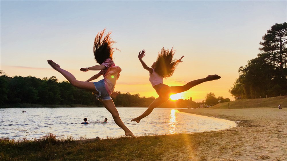 Deux jeunes danseuses performantes devant l'objectif au soleil couchant