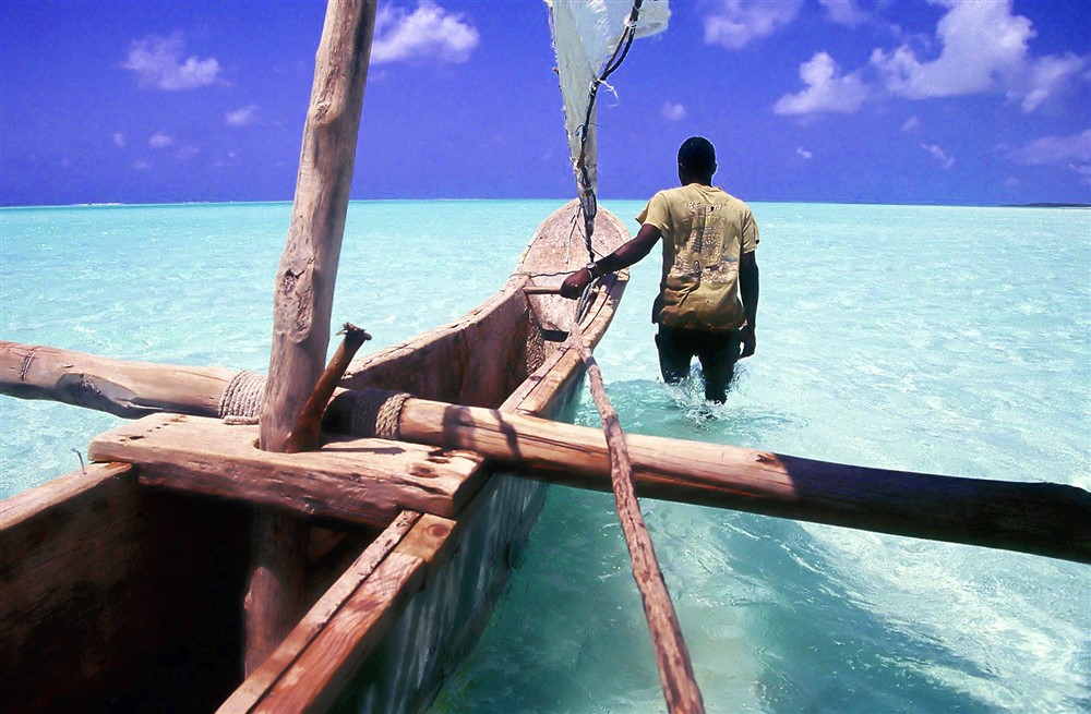 Pêcheur de Zanzibar à côté de sa barque